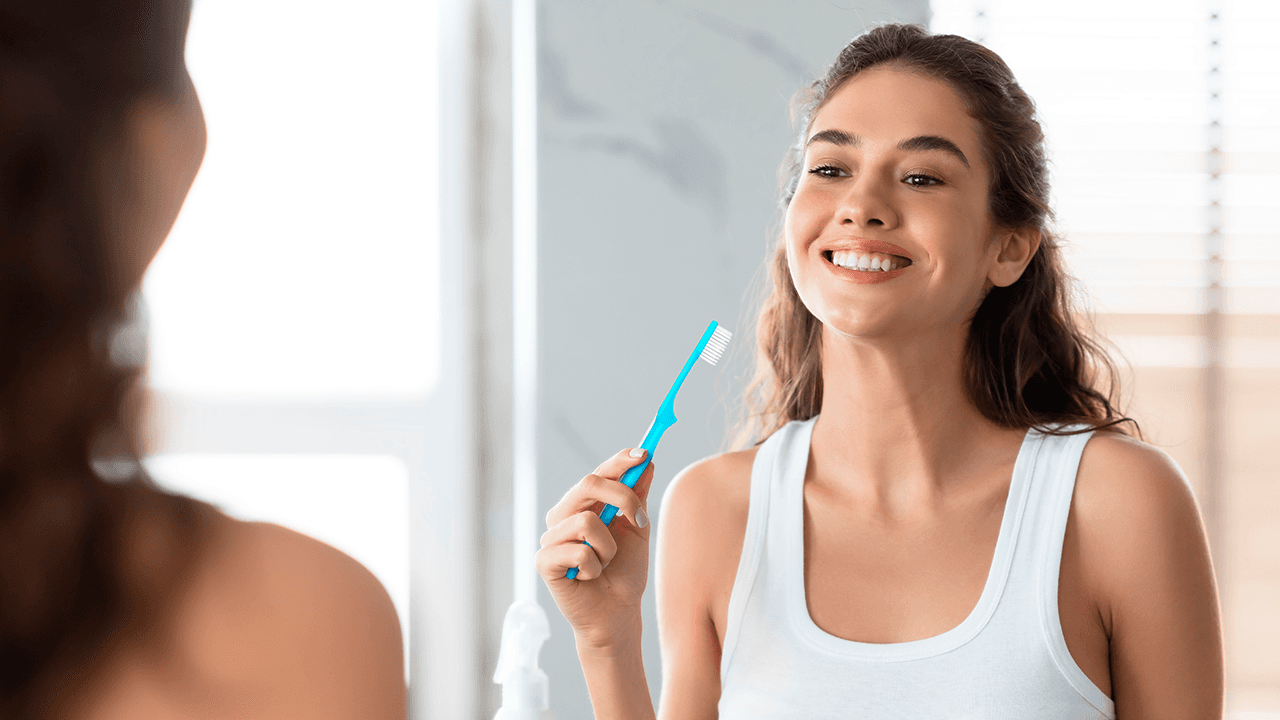 woman brushing her teeth with a TePe Supreme toothbrush