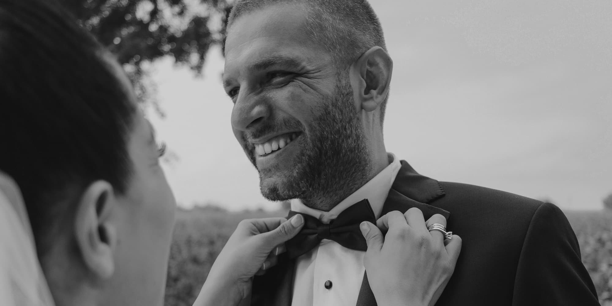 Woman fixing her husbands bowtie on their wedding day